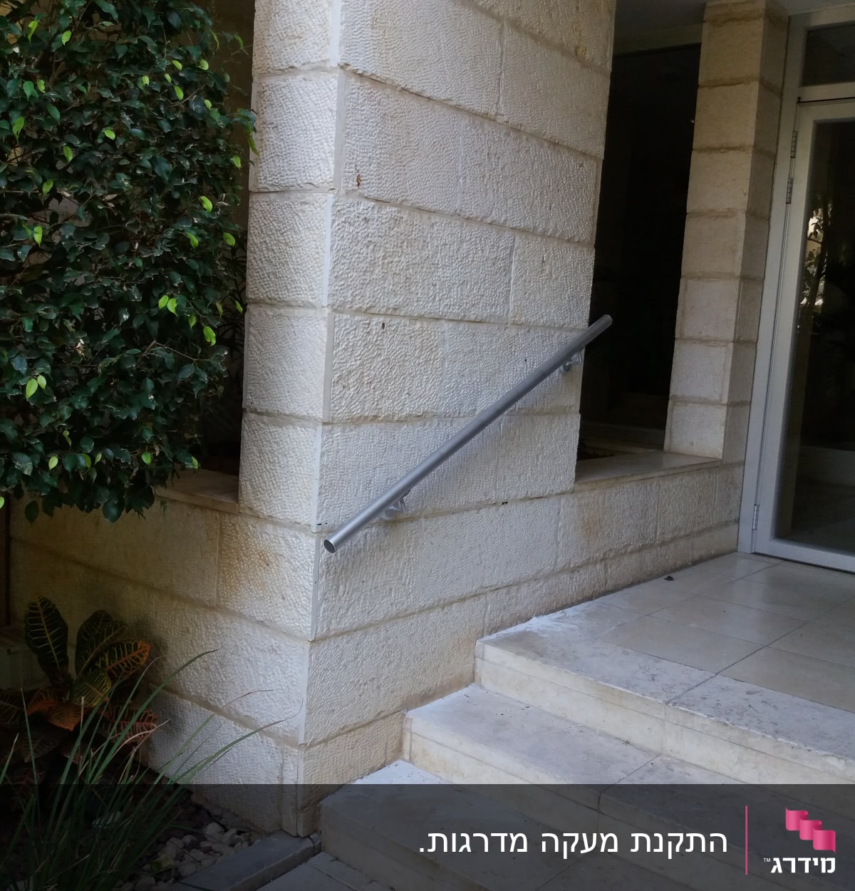 מעקה מתכת ליד דלת זכוכית במסגרת אלומיניום